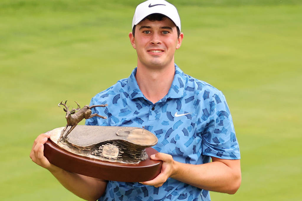 Davis Thompson holds the trophy after winning the John Deere Classic in 2024